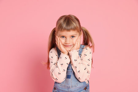 Portrait of cute little girl on pink backgroundの写真素材