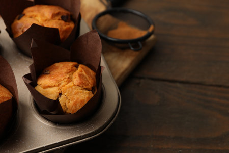 Tasty muffins with raisins on wooden table, closeup. Space for textの写真素材