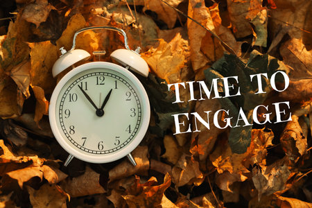 Time to get involved. Alarm clock on fallen leaves outdoorsの写真素材