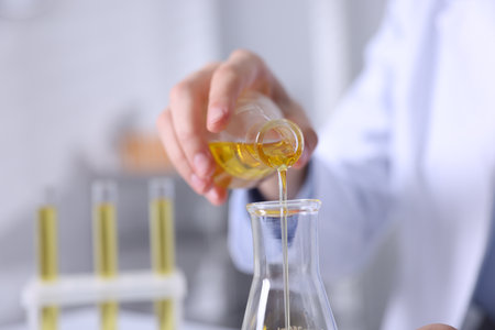 Scientist pouring motor oil into flask in laboratory, closeupの写真素材