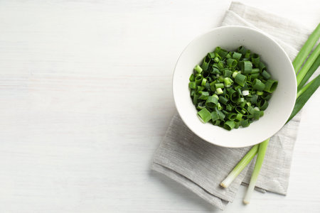 Fresh green onions on white wooden table, top view. Space for textの写真素材