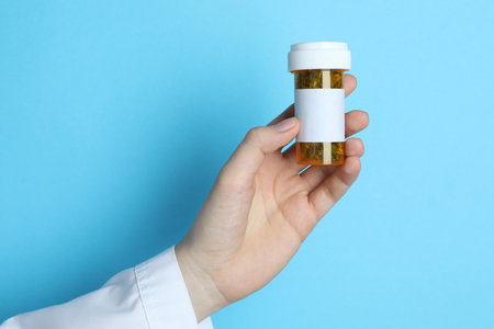 Doctor with dried medicinal herbs on light blue background, closeupの写真素材