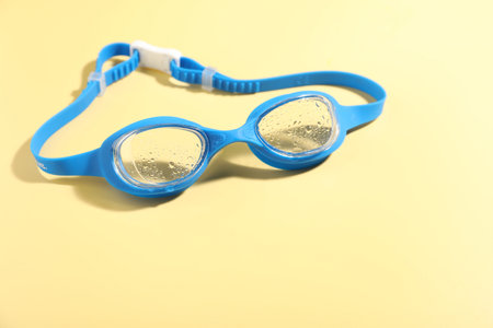 Swimming goggles on yellow background, closeup. Space for textの写真素材