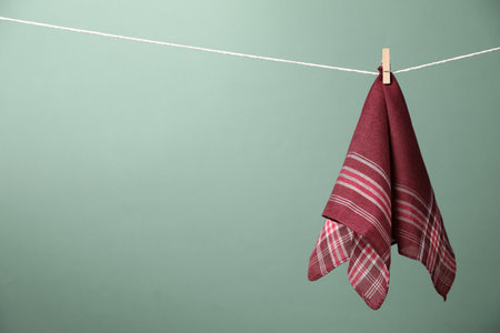 Beautiful cotton handkerchief hanging on string against olive background.の写真素材