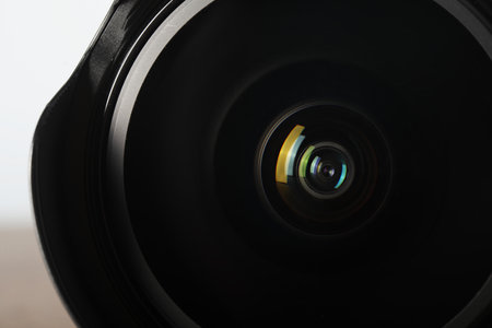 Professional camera lens on light background, closeup. Photographer's equipment
