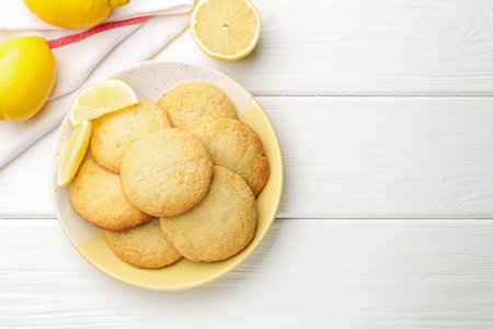 Tasty lemon cookies and fruits on white wooden table, flat lay. Space for text