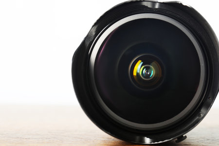 Professional camera lens on wooden table, closeup. Photographer's equipment
