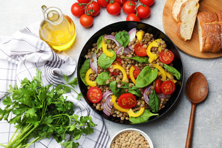 Tasty salad with lentils and vegetables served on gray table, flat layの写真素材