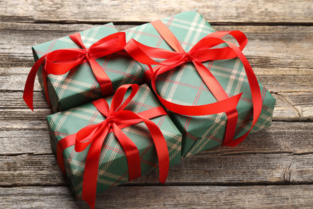 Beautiful gift boxes wrapped in checkered paper on wooden table