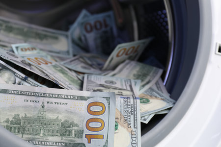 Many dollar banknotes in washing machine, closeup