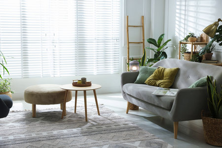 Stylish living room with sofa and houseplants. Interior design