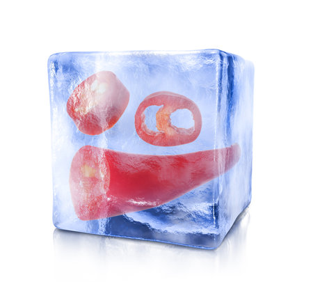 Sliced red chili pepper in ice cube isolated on whiteの写真素材