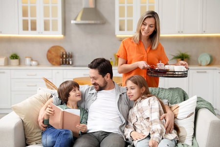 Happy family spending time together on sofa in kitchen at homeの写真素材