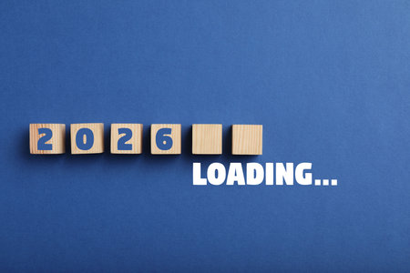 Wooden cubes with numbers on blue background, top view