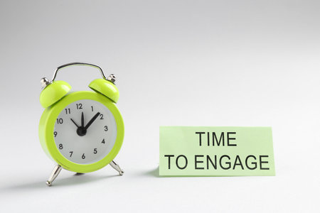 Card with text Time To Engage and alarm clock on white background