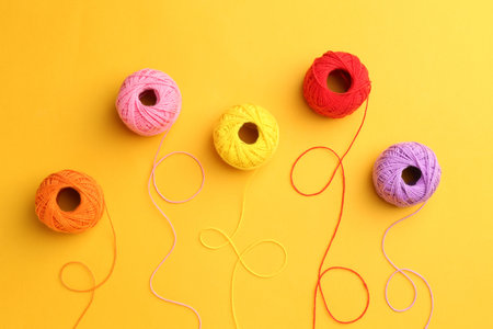 Balls of different yarns on yellow background, flat layの写真素材