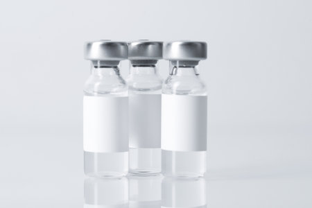 Vaccine in vials on mirror surface against gray background, closeupの写真素材