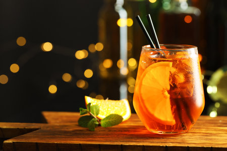 Refreshing spritzer cocktail, mint and orange slice on wooden table in bar, closeup. Space for textの写真素材