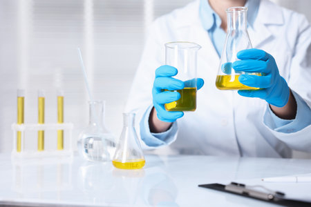 Scientist checking oil quality at table in laboratory, closeup
