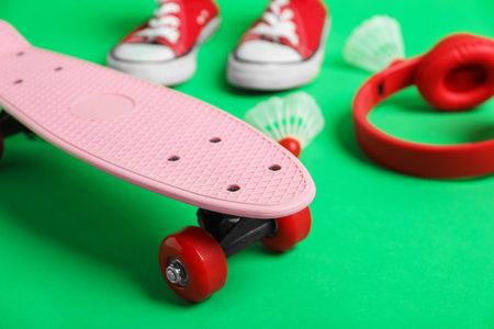 Penny board, shuttlecocks, headphones and sneakers on green background, closeupの写真素材