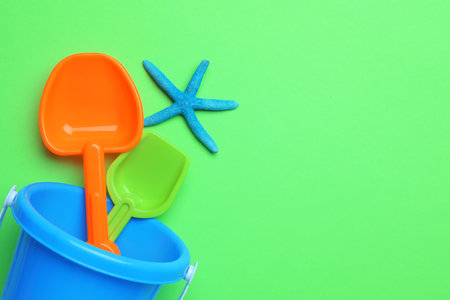 Children's beach toys and starfish on green background, flat lay. Space for textの写真素材