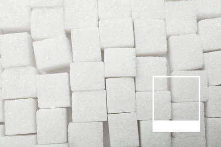Many cubes of sugar as background, top view. Frame highlighting trendy color