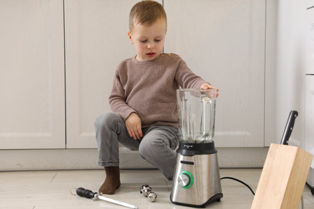 Child safety at home. Little boy playing with kitchen supplies indoorsの写真素材