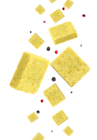 Bouillon cubes and peppercorns flying in the air on white backgroundの写真素材