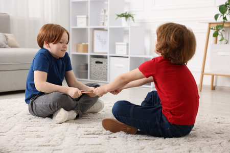 Two brothers arguing over tablet on floor at home