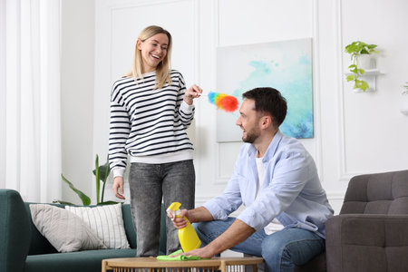 Couple tidying up living room together. Domestic chores