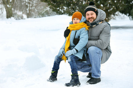 Father and his son spending time together outdoors on winter day, space for textの写真素材