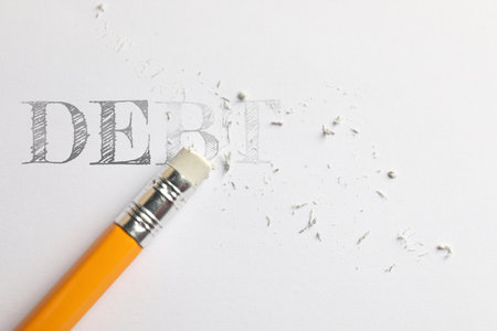 Erasing word Debt written in on white background, top view