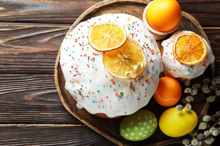 Beautiful Easter cakes, eggs and willow on wooden table, flat lay