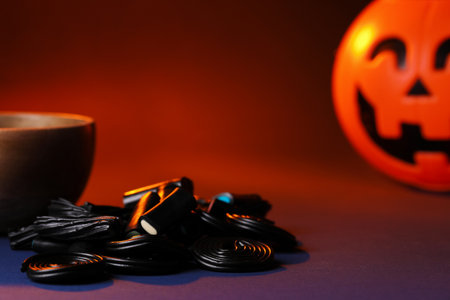 Natural licorice candies and pumpkin on color background, closeupの写真素材
