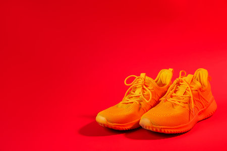 Pair of stylish sneakers on red background. Space for textの写真素材