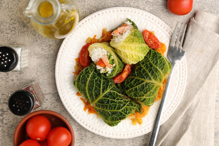 Stuffed cabbage rolls served with vegetables on gray background, flat layの写真素材