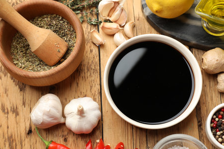 Soy sauce and other different ingredients for marinade on wooden table, flat layの写真素材
