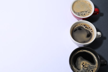 Cups of aromatic coffee on color background, above view. Space for textの写真素材