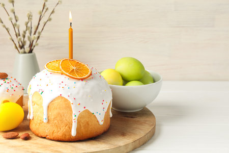Tasty Easter cakes, painted eggs and willow branches on white wooden table, closeup. Space for text