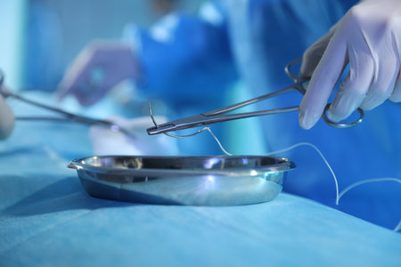 Professional surgeon with medical instruments performing operation in surgery room, closeup