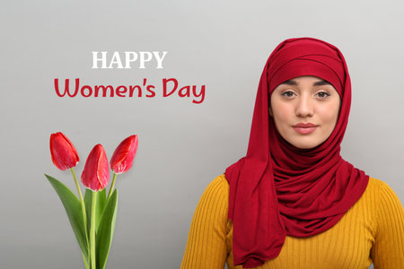 Muslim woman in hijab and bouquet of tulips on gray background.の写真素材