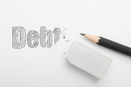Erasing word Debt written in on white background, top view