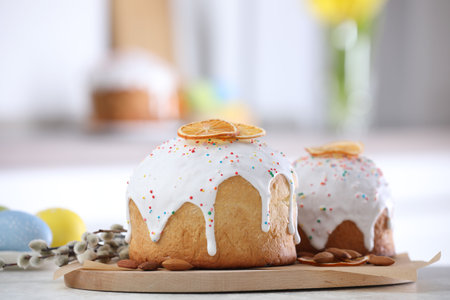 Tasty Easter cakes, painted eggs and willow branches on white table, closeup
