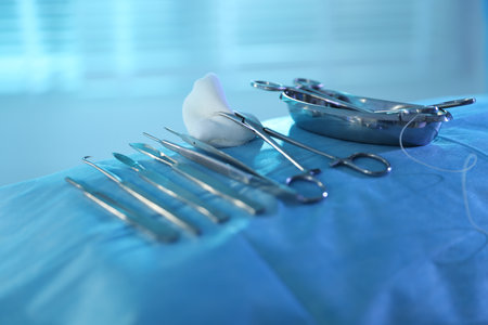 Different surgical instruments on sterile drape in hospital, closeup