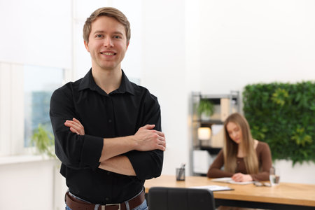Portrait of smiling recruiter with crossed arms and candidate in office, selective focus. Space for textの写真素材
