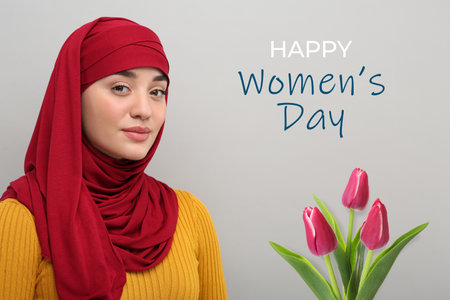 Muslim woman in hijab and bouquet of tulips on gray background. Happy Women's dayの写真素材