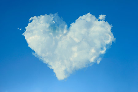 Cute fluffy heart-shaped cloud in blue skyの写真素材