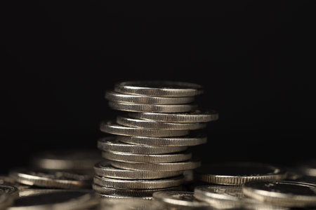 Stack of coins on black background, closeup