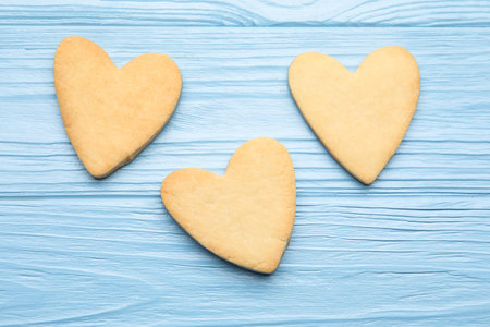 Delicious heart shaped butter cookies on light blue wooden table, flat layの写真素材