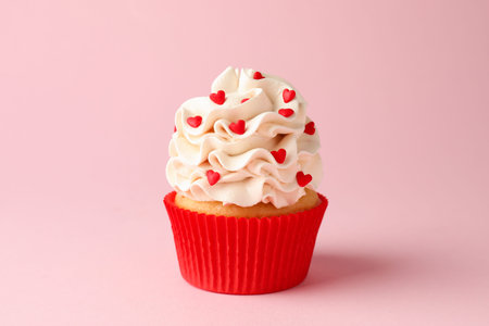 Happy Valentine's Day. Tasty cupcake with red hearts on pink background, closeupの写真素材